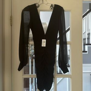 Black long sleeved cocktail dress with sheer long sleeves. Never worn